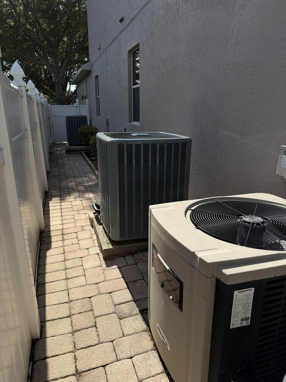 No obstacle is too big for the right team. This outdoor condenser installation required precision maneuvering to lift the unit over existing exterior equipment and into its permanent home. We specialize in difficult AC placements and custom site solutions.